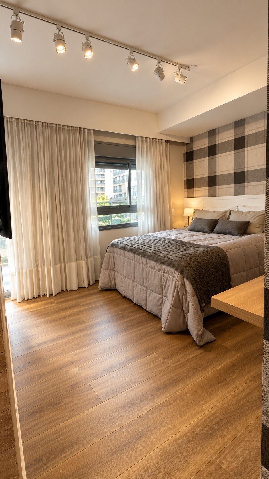 Bedroom with track lighting, curtains and floating desk