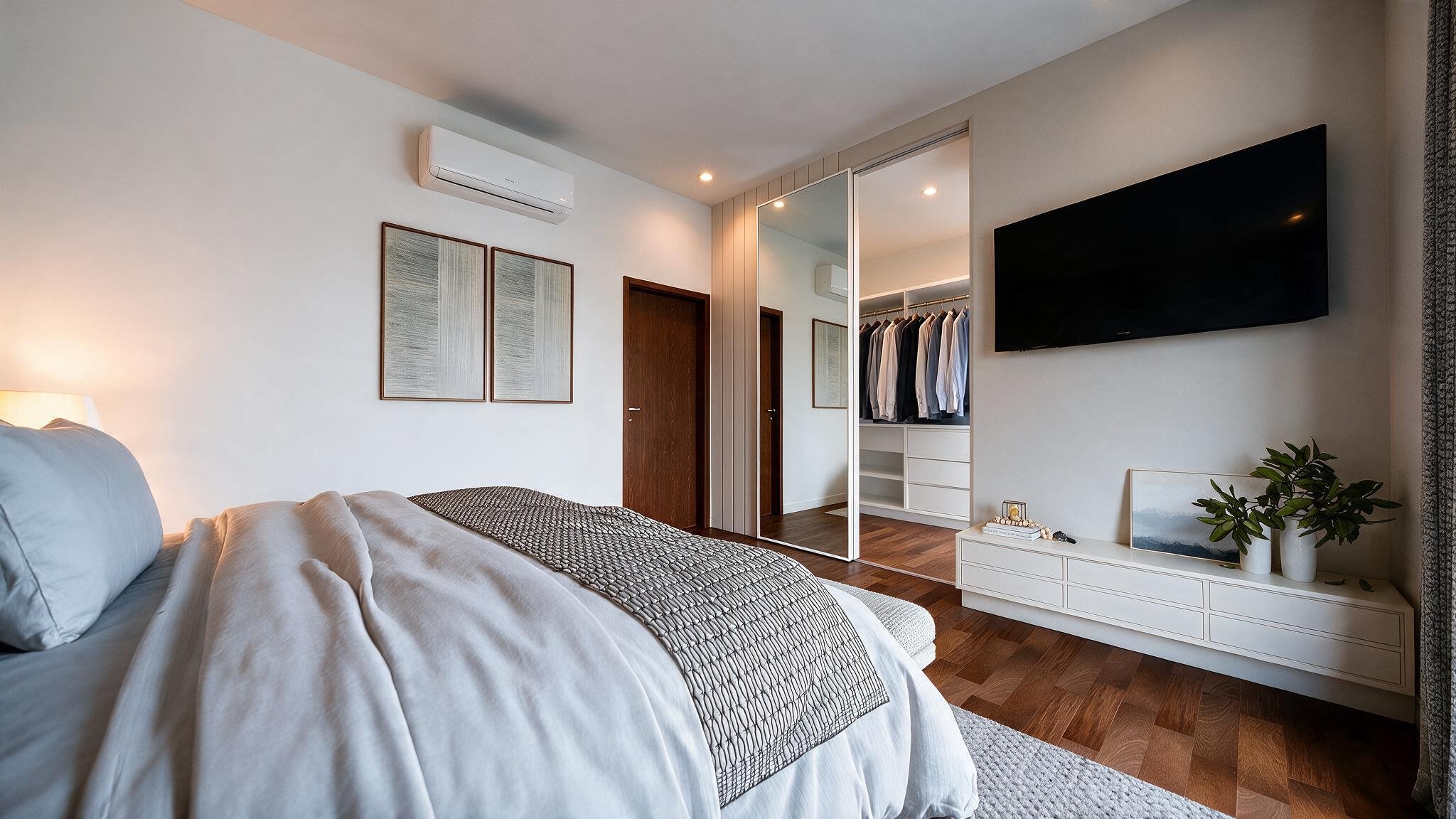 Suite with mirrored closet door and wall-mounted TV